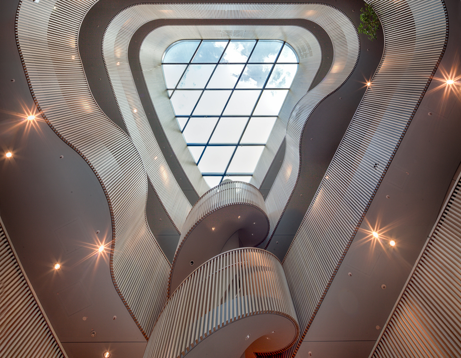 Aloys Kiefer Architekturfotografie: Innenansicht vom Turm der Behörde mit Holzgeländer mit Blick gegen das gläserne Dach.