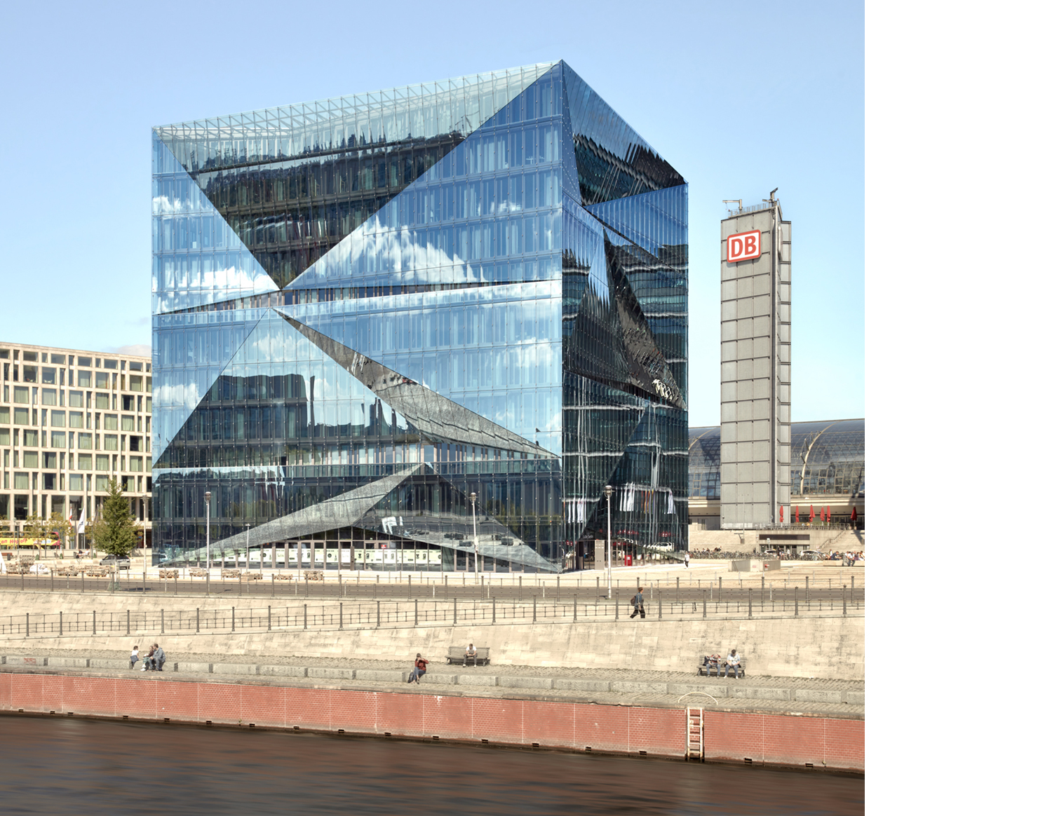 Aloys Kiefer Architekturfotografie: Quadrattisches Motiv. Bläulicher Glaskubus, rechts im Hintergrund ein schlanker Turm mit der Aufschrift DB.